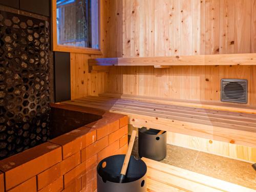 a wooden sauna with a wooden stick in it at NIPPONIA Sado 佐渡相川 金山町 in Sado