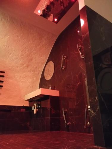 a bathroom with a red marble wall and a counter at La suite miroir, love room avec jacuzzi in Bouc-Bel-Air