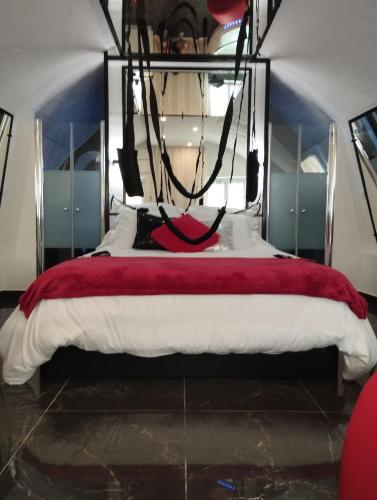 a bedroom with a bed with a chandelier at La suite miroir, love room avec jacuzzi in Bouc-Bel-Air