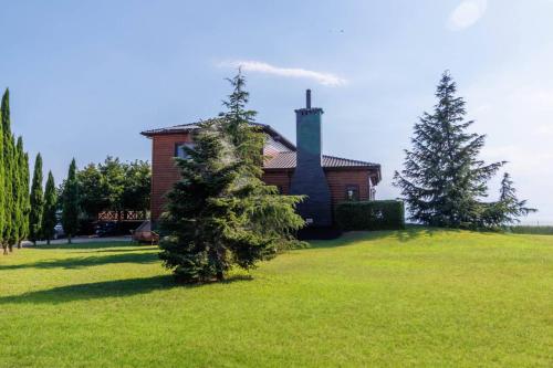 a house in a field with trees in front of it at Villa PARADISE in Néa Michanióna
