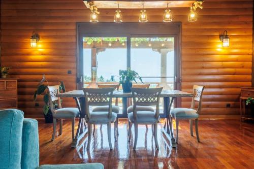 a dining room with a table and chairs at Villa PARADISE in Néa Michanióna
