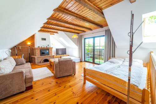 a bedroom with a bed and a living room at Ardea Mikołajki domek in Mikołajki