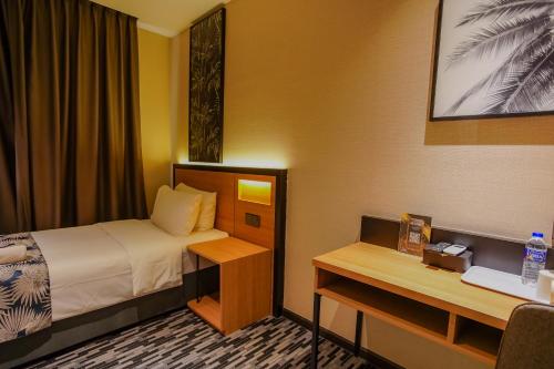 a small hotel room with a bed and a desk at NB HOTEL in Johor Bahru