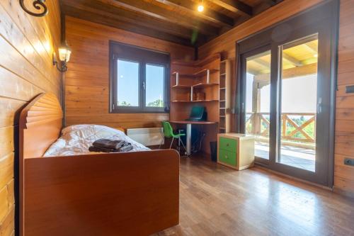 a bedroom with a bed in a room with wooden walls at Villa PARADISE in Néa Michanióna