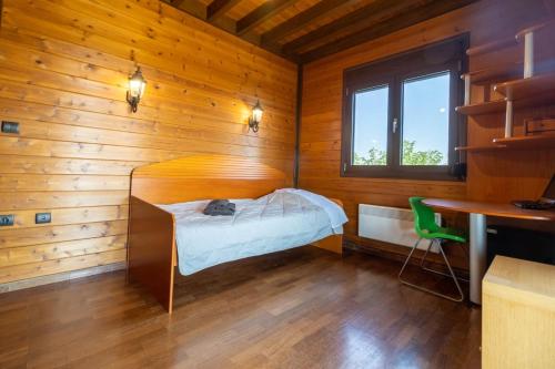 a small bedroom with a bed in a wooden room at Villa PARADISE in Néa Michanióna