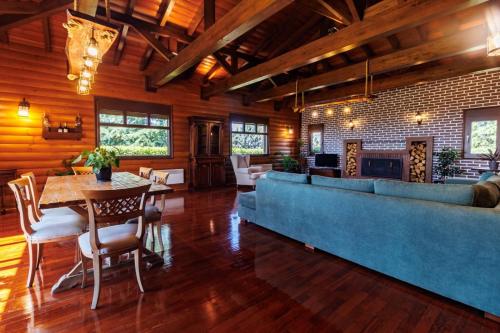 a living room with a blue couch and a table at Villa PARADISE in Néa Michanióna