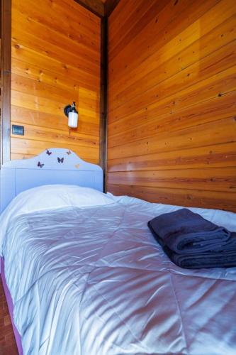 a bedroom with a white bed in a wooden wall at Villa PARADISE in Néa Michanióna