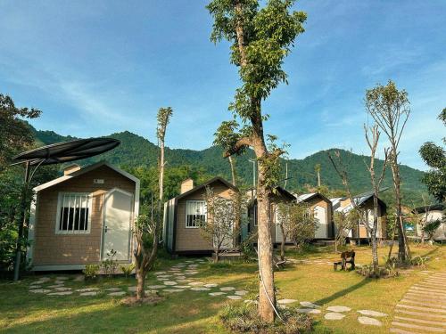a row of cottages with mountains in the background at Halo Retreat in Hòa Bình