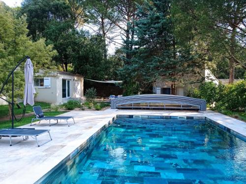 - une piscine avec un banc dans l'arrière-cour dans l'établissement Le Mimosa des Cévennes, à Anduze