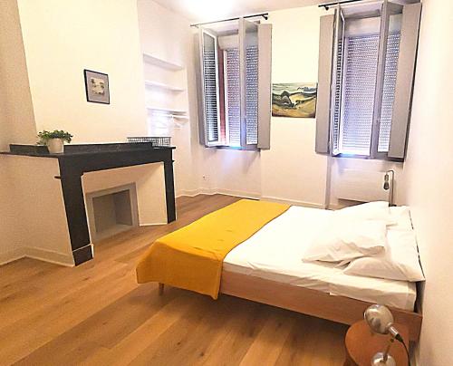 - une chambre avec un lit, une cheminée et des fenêtres dans l'établissement Hypercentre Capitole T2 vaste et lumineux, à Toulouse