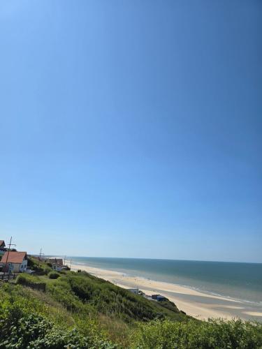 a view of a beach with the ocean in the background at Mobil-home Vue mer Piscine - Camping La Falaise Equihen-Plage - La Coquille d'Opale in Équihen-Plage