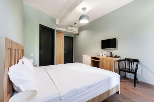 a bedroom with a bed and a desk and a television at Hotel InnDigo in Kutaisi in Kutaisi