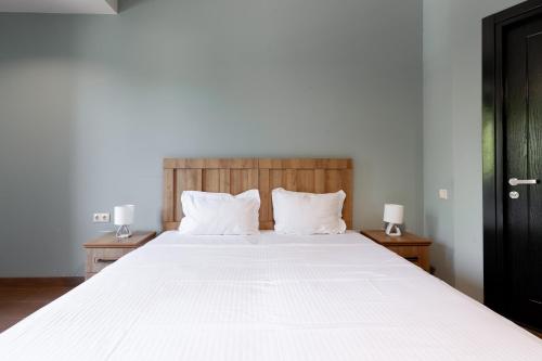 a bedroom with a large white bed with two lamps at Hotel InnDigo in Kutaisi in Kutaisi
