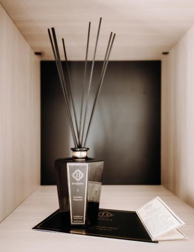 a vase with a candle and a book on a table at Hotel Eldorado in Apiro
