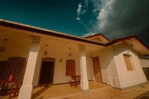 a house with a patio with a table and chairs at White on White in Hikkaduwa