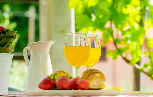 a glass of wine and some fruit on a table at Villa Imortele aria with pool by Villas Guide in Cres