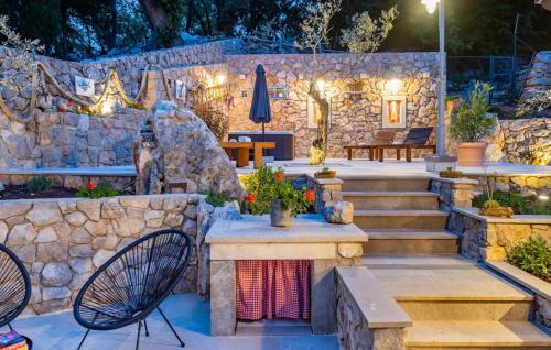 a patio with stairs and a stone wall at Villa Imortele aria with pool by Villas Guide in Cres