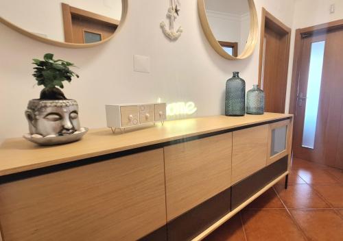 a counter with a vase on top of it with mirrors at albufeira sweety house in Albufeira