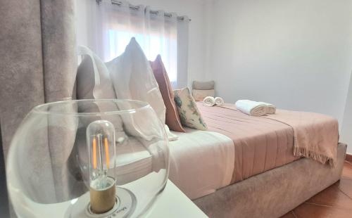 a bedroom with a bed and a table with a glass vase at albufeira sweety house in Albufeira