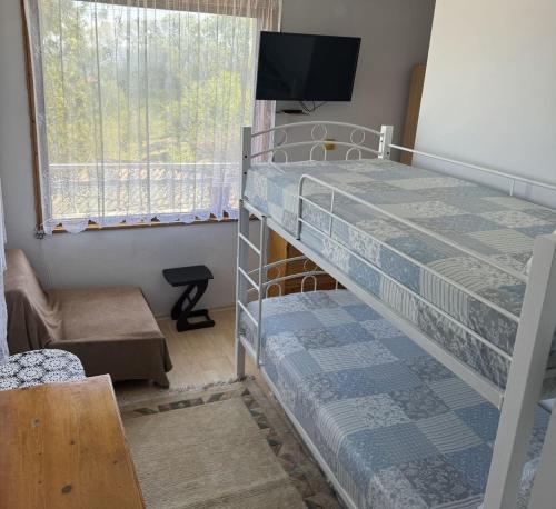 a bedroom with a bunk bed with a tv on top at Етаж от къща - Желкови in Varna City