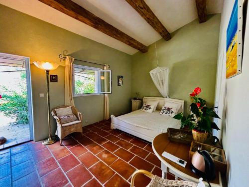 a bedroom with a bed and a table in a room at La Farigoulette in Taradeau