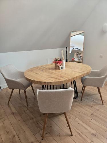 a dining room table with chairs and a mirror at Duplex sous les toits d'Alsace in Dannemarie