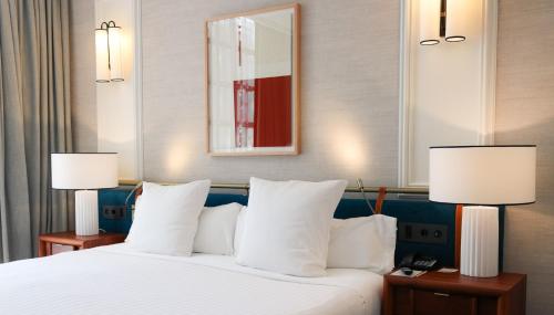a hotel room with a bed with two lamps at Hospes Palacio de los Patos, a Member of Design Hotels in Granada