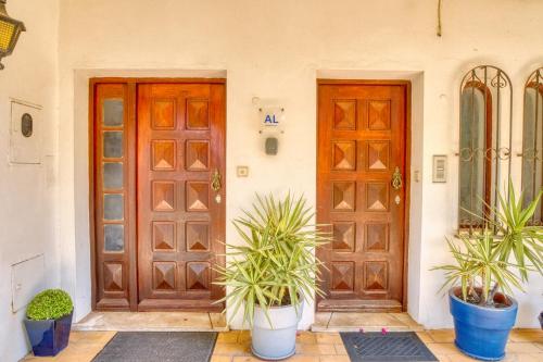 two doors and potted plants in front of a house at Casa Teles in Quarteira