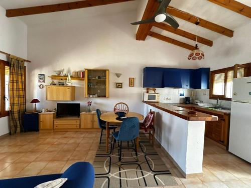 een keuken met blauwe kasten en een tafel en stoelen bij Casa Les Palmeretes, Alicante in El Campello