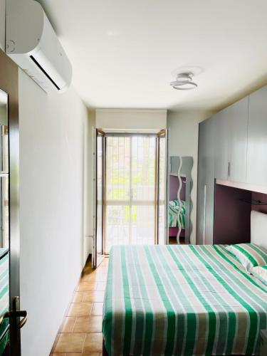 a bedroom with a green and white bed and a window at Z37 4bed, terrace, tennis and summer pool, 10 min Milan in Opera