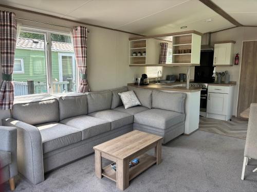 a living room with a couch and a kitchen at 10 Borwick Lakes, Carnforth - En suite - King size bed in Carnforth
