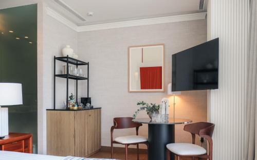a room with a table and chairs and a tv at Hospes Palacio de los Patos, a Member of Design Hotels in Granada