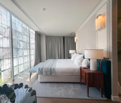 a bedroom with a bed and a large window at Hospes Palacio de los Patos, a Member of Design Hotels in Granada