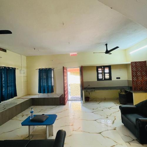 a living room with a ceiling fan and a table at Vistara Beach Resort Malpe - Udupi in Udiyāvara
