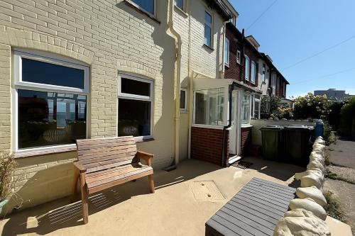 a wooden bench sitting outside of a house at 4 Seaview Sheringham in Sheringham