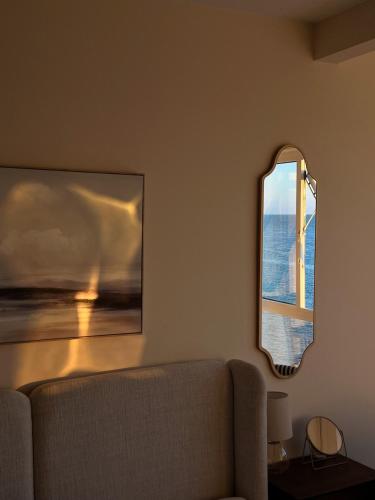 a living room with a couch and a mirror at 4 Seaview Sheringham in Sheringham