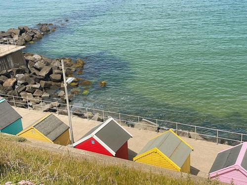 a row of colorful beach huts next to the water at 4 Seaview Sheringham in Sheringham