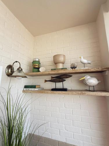 a room with shelves on a white brick wall at 4 Seaview Sheringham in Sheringham