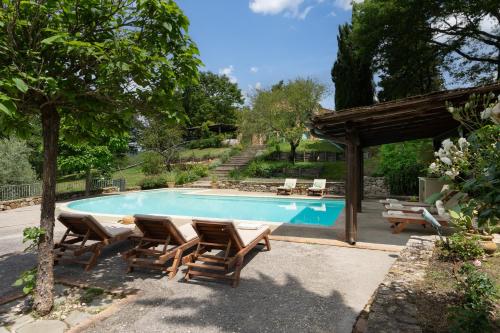 a swimming pool with chairs and a gazebo at Villa Vesta by My Villa Collection in San Casciano dei Bagni