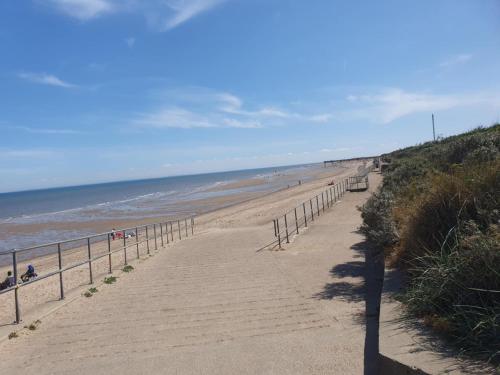 a path leading to a beach with people on it at 3 Bed Caravan sleeps 8 in Skegness