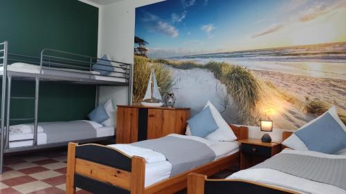 two beds in a room with a beach mural at Agroturystyka Wypoczynkowa II in Zieleniewo