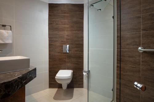 a bathroom with a toilet and a glass shower at Premier Hotel Cape Town in Cape Town