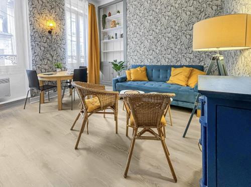 a living room with a blue couch and chairs at Superbe appartement cosy et chaleureux EN PLEIN CENTRE Idéal pour un couple, une petite famille ou professionnel in Poissy