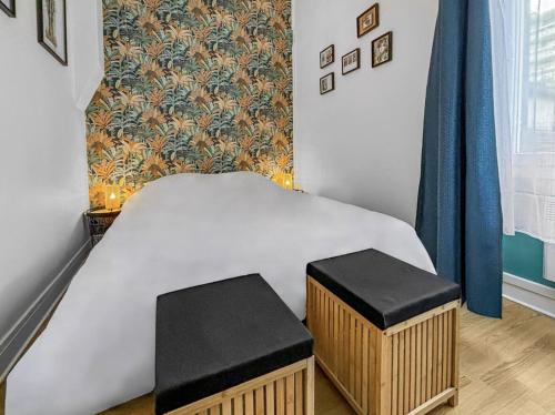 a small bed with two stools in a bedroom at Superbe appartement cosy et chaleureux EN PLEIN CENTRE Idéal pour un couple, une petite famille ou professionnel in Poissy