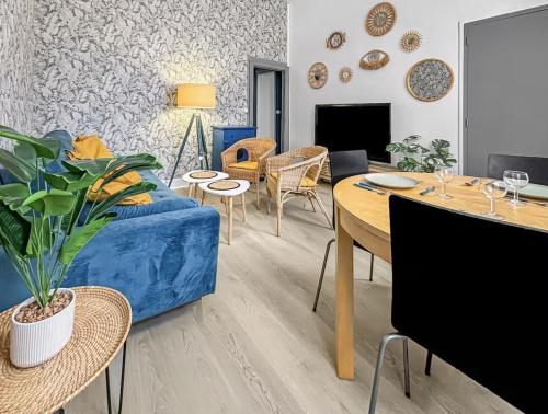 a living room with a blue couch and a table at Superbe appartement cosy et chaleureux EN PLEIN CENTRE Idéal pour un couple, une petite famille ou professionnel in Poissy