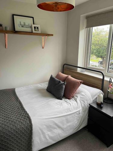 a bedroom with a bed with two pillows on it at Charming 2-Bed Apartment with free parking 10 mins drive to York City in York