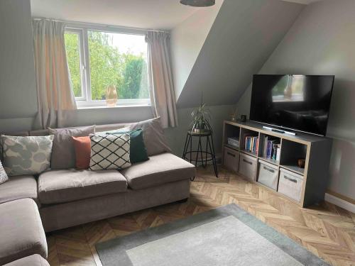 a living room with a couch and a flat screen tv at Charming 2-Bed Apartment with free parking 10 mins drive to York City in York