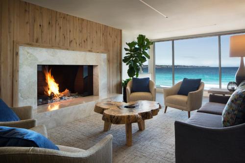 a living room with a fireplace and the ocean at Monterey Tides in Monterey