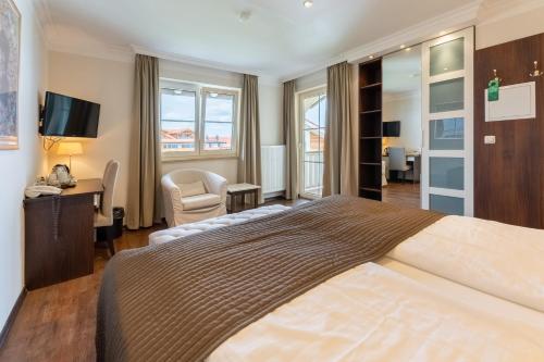 a hotel room with a large bed and a desk at ChiemseeStern Vacation & Recreation "Adults Only" in Gstadt am Chiemsee
