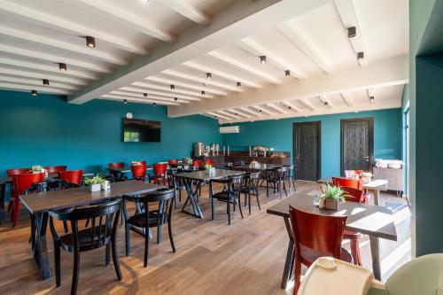 a dining room with tables and chairs and blue walls at Hotel InnDigo in Kutaisi in Kutaisi